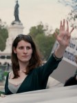 Transsexual woman July Schultz displaying her palm with the letters "XY" written on it at an outdoor demonstration